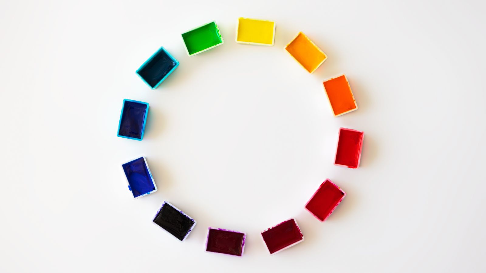 The colour wheel represented with paints in pots.